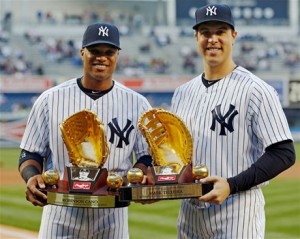 El segunda base Robinson Canó, a la izquierda y el primera base Mark Teixeira, ambos de los Yankees, posan con sus premios Guante de Oro 2012 antes de un partido de anoche.