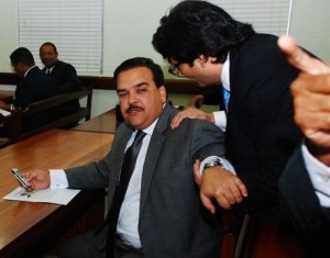 Elías Wessin Chávez habla con su abogado en el tribunal antes de anunciarse el aplazamiento de la audiencia.