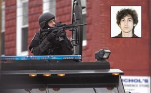 Un agente de la de policía de Boston apunta con su arma durante el registro de un apartamento. | EFE