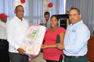 Raymundo Lebron y Carlos Rojas entregan una canastilla a una de las madres embarazadas a nombre de Miguel Bogaert