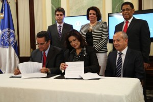 La viceprsidenta Cedeño de Fernández mientras firma el acuerdo con el rector de la UASD, Iván Grulló. Funge de testigo el ministro de Salud, Freddy Hidalgo