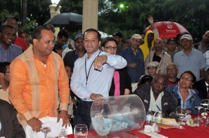 Alcalde Juan de los Santos saca una de los obras de la tombola