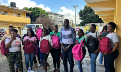 El candidato a diputado por el PHD, Amauris Fabián, junto a estudiantes a quienes entregó útiles escolares.