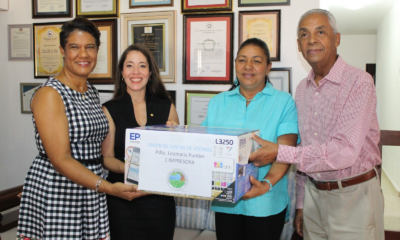 Rossy Ruíz, Ariadna Méndez y José Tejeda entregan una computadora a Leomaris Puntiel, presidenta de la Unión de Juntas de Vecinos de Jarabacoa