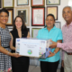 Rossy Ruíz, Ariadna Méndez y José Tejeda entregan una computadora a Leomaris Puntiel, presidenta de la Unión de Juntas de Vecinos de Jarabacoa